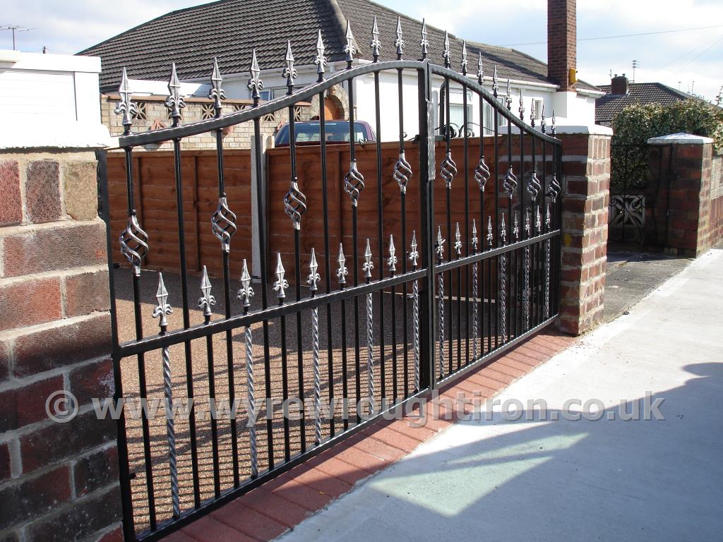 Double arch gates with railheads, cages twists and twisted bars. Powder coated in black and fitted to a property near Stannah, Poulton-le-Fylde.