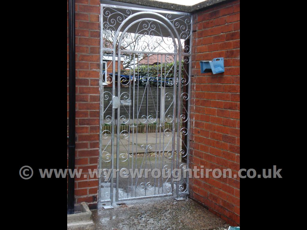 Tall single arched gate with scrollwork design, matching scrollwork frame and lockable slide bolt providing security for the rear garden. Fitted in Carleton, near Blackpool.